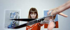 A woman holding scissors looking at the camera